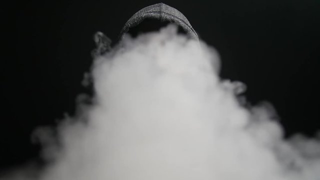 Man exhales vapors into camera in slow motion.