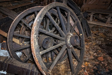 Fototapeta na wymiar old rusty wagon wheels in a barn