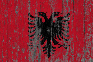 Flag of Albania painted on worn out wooden texture background.