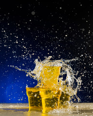 water in plastic cups and splashes, on blue background