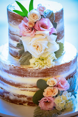 Two-tiered wedding cake with white and pink roses decoration