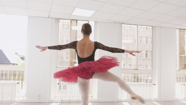 Ballerina performing fouetté turns in a bright studio, medium orbit shot