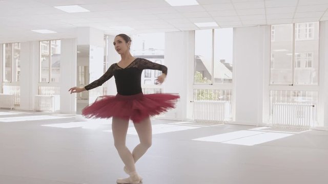 Slow motion arc shot of a ballerina performing a single pirouette