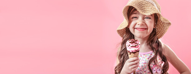 Cute little girl with ice cream on pink background