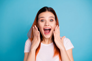 Close up photo  charming pretty youth lovely astonished impressed by incredible novelty  rumor gossip place hands palms near cheeks face open mouth wonder shout isolated  t-shirt  blue background