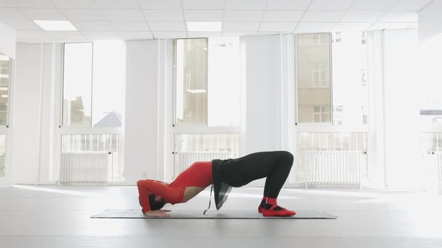Beautiful shot of a ballerina doing a bridge with a stretched leg, push in pull out slow motion video