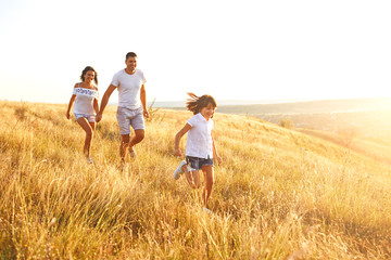 Fototapeta na wymiar Happy family walking in nature at sunset in summer.