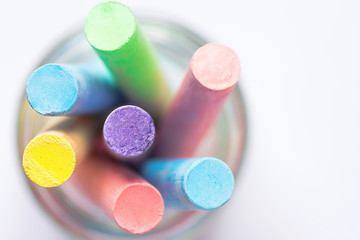 Bunch of Multicolored Chalks Crayons in Pencil Cup. Top View White Background. Education Arts Crafts Creativity Concept. Elegant Minimalist Style. Website Poster Banner Template. Copy Space