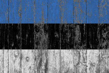 Flag of Estonia painted on worn out wooden texture background.
