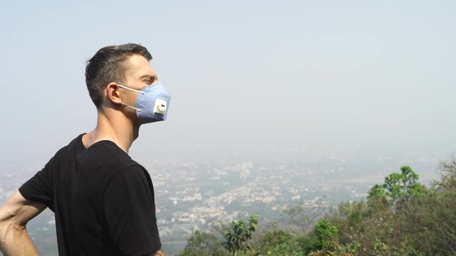 Young man wearing  face mask in air pollution. A highly toxic polluted air quality index reached 300 in Chiang- Mai city of Thailand