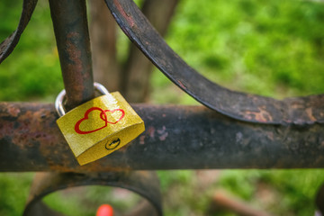 Golden castle with the image of two red hearts on an old metal fence