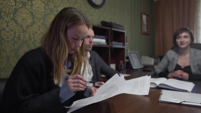 Caucasian Couple Exploring Documents in Contract in Realtors Office Before Buying New Real Estate Property. Light Camera Movement