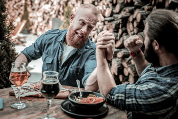 Two mature men squaring off in arm-wrestling.
