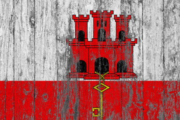 Flag of Gibraltar painted on worn out wooden texture background.