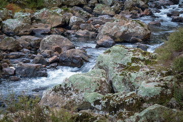 Naklejka na ściany i meble River rapids over boulders