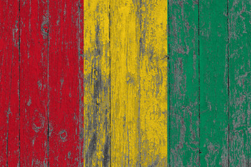 Flag of Guinea painted on worn out wooden texture background.
