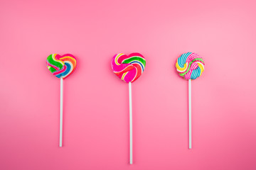 Multicolored lollipops on a pink background
