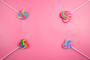 Multicolored lollipops on a pink background
