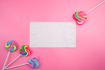 Multicolored lollipops on a pink background