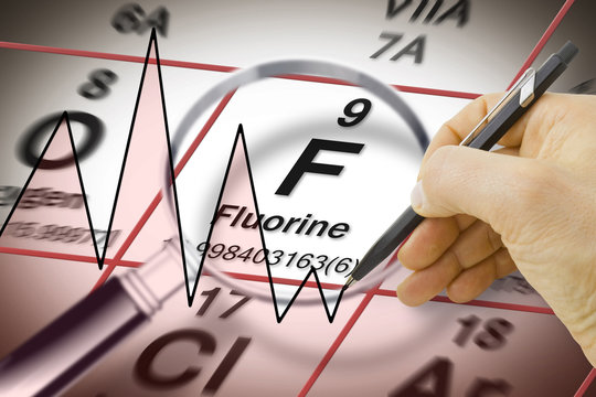 Focus on fluorine chemical element - the most important element against tooth decay - concept image with a chart above the Mendeleev periodic table