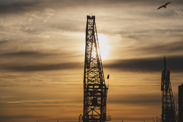 Obraz premium silhouette of a construction crane at sunset sky evening