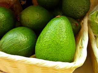 Ripe fresh avocado in a basket on a market shelf. Healing food concept.