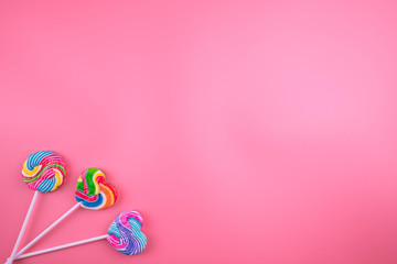 Multicolored lollipops on a pink background
