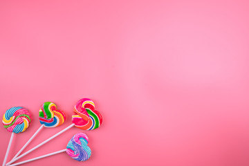 Multicolored lollipops on a pink background