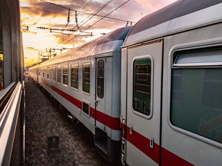 Obraz premium Train moving on railroad track at sunset