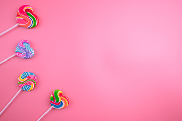 Multicolored lollipops on a pink background