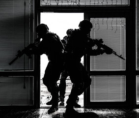 SWAT team breaching door and storming apartments - obrazy, fototapety, plakaty