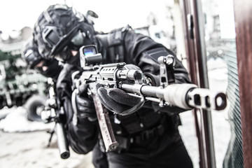 Fototapeta na wymiar Police special reaction team member aims with gun