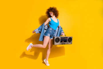 Full length body size photo beautiful she her lady wavy styling curls old-fashioned tape recorder dancing excited wear specs casual jeans denim shirt shorts tank top clothes isolated yellow background