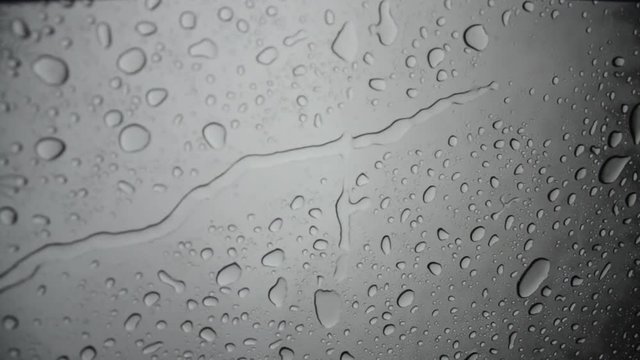Raindrops flow down the glass
