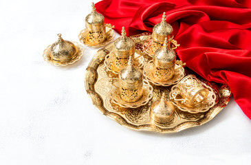 Fototapeta na wymiar Arabic tea coffee service golden cups Ramadan Holidays decoration