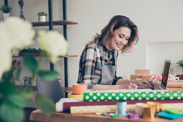 Portrait positive cheerful content satisfied successful vendor modern technology orders note book bouquet bunch plan holiday 8-march floral nature wavy curly haircut trendy stylish shirt plaid indoors