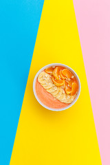 Homemade yogurt tangerines and bananas on a plate on colored backgrounds. fresh fruit on a colored background. top view