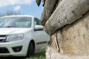An old painted barn in the village against the background a white car on a sunny day. Canon EOS 77D, f/5.6 ISO100 1/250