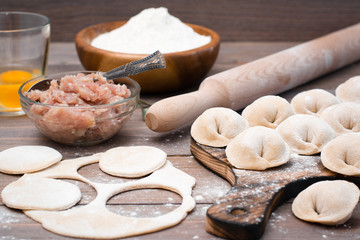 The process of molding dumplings and ingredients for cooking on a wooden table