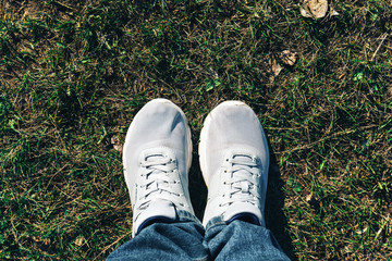 white sneakers on green grass top view