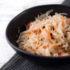 Sauerkraut at white rustic wooden background. Typical fermented food in some countries such as Russia, Poland or German.