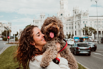 .Young woman doing dog friendly tourism with her pet in the city of Madrid. Touring the center of the city. Travel photography. Lifestyle