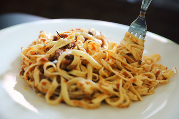 spaghetti Bolognese with minced beef and tomato sauce garnished with parmesan cheese and basil , Italian food