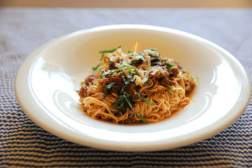 spaghetti Bolognese with minced beef and tomato sauce garnished with parmesan cheese and basil , Italian food