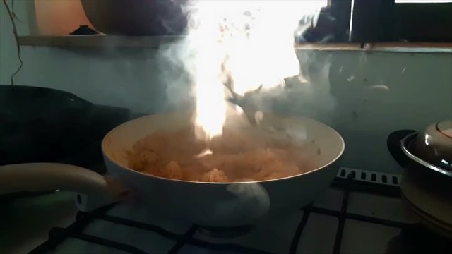 Sun rays shining through rising steam comming out of hot pan in slow motion. Filmed at home while cooking cabbage with sun shining through window.