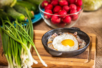 Fried eggs with bacon in a pan.