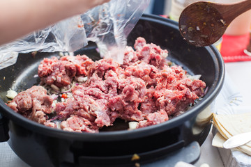 Putting beef meat in the pan