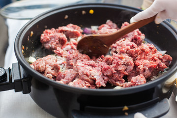 Putting beef meat in the pan