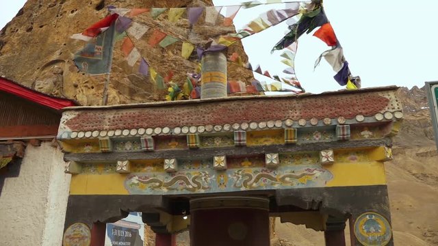 Low angle close-up shot of a prayer wheel building's  roof decorated by paintings and coloured flags of khata. It is next  Mulbekh monastery's  temple,  Kargil Leh road. 