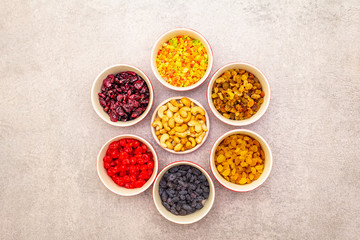Dried and candied fruit and cashew nuts. Assorted in ceramic bowls on a stone background. Healthy...